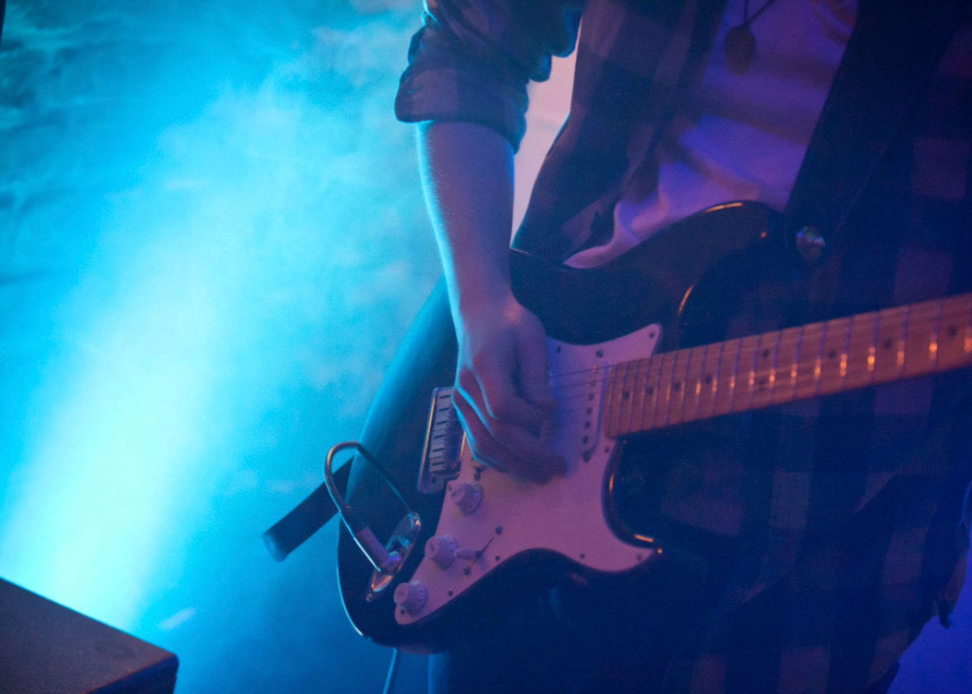 Gitarrist live auf der Bühne mit blauem Licht